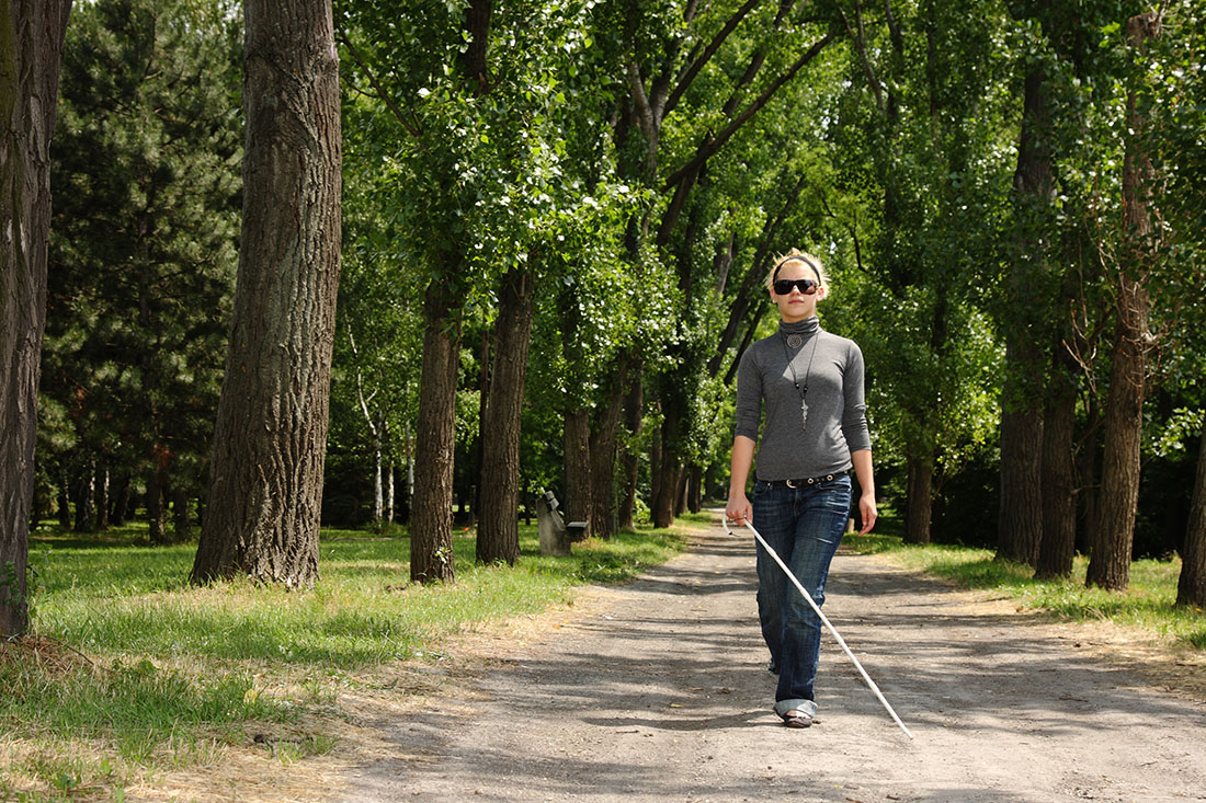 Woman with cane walking in a park